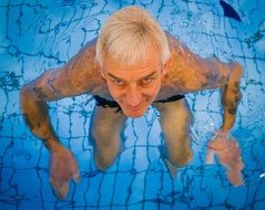 A man stands in a pool with clear water