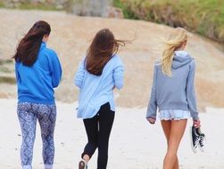 girls walking along the beach