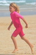 little girl in pink on a sandy beach