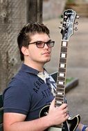 young man with a guitar on the street