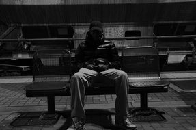 Young man is sitting on the bench