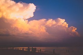 people on the beach on a background of clouds