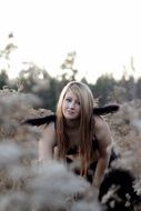 Photo of young girl sitting in a high grass