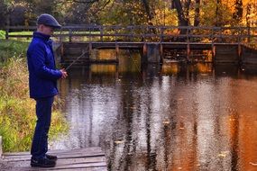 man fishing in the pond in autumn