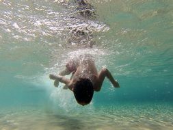 boy diving in turquoise water