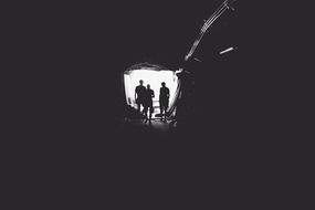 silhouettes of people at the end of the tunnel