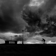 Man on bicycle cloudly bad weather scene