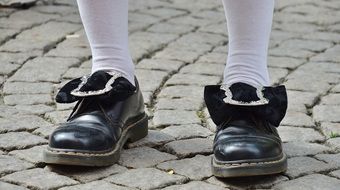 Men's legs in black shoes stand on the paving stones