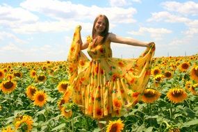 Girl in the sunny dress on background of sunflowers