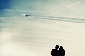 aircraft and silhouette of couple at blue sky