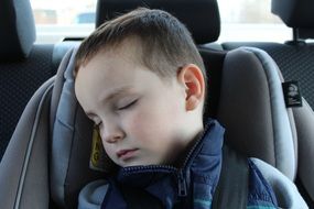 portrait of sleeping baby in a car