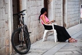 girl sitting on a chair in the street