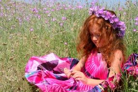 red-haired girl with a wreath on the background of flowers