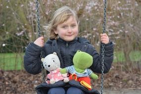 child with toys on swing