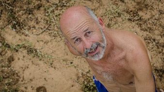 man with a gray beard on the beach