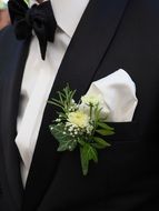 flower is pinned to the suit of the groom