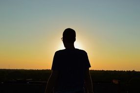 dark male silhouette at sunset sky