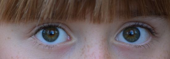 wide open eyes of red haired child girl