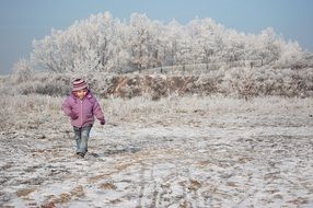 child boy walking in countryside at winter