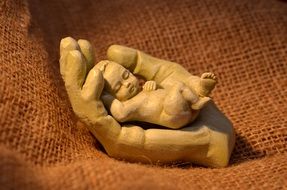 Sculpture of child in a hand