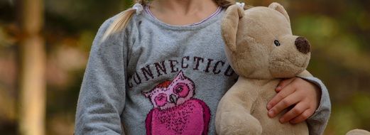 child holding a teddy Bear
