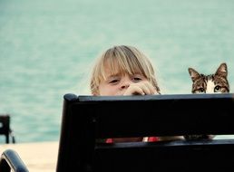 baby and cat on a bench