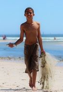 boy goes with fish in his hands