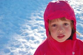 sad child girl in red hoodie at snow