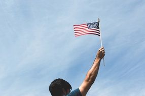 Man holding american flag sky view