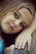 little girl posing while lying on her hand