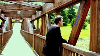 thinking man on a wooden bridge