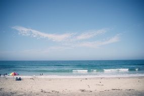 landscape of people on a sandy beach near the sea