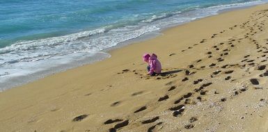 child on a sandy beach near the sea