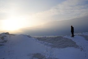 Lonely man is on a snowy mountain