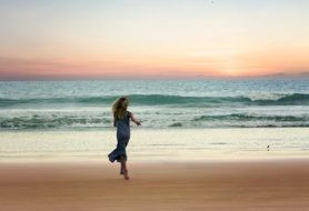 Girl running on beach sunset view