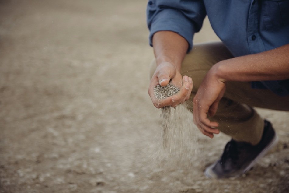 Man taking the sand by fingers