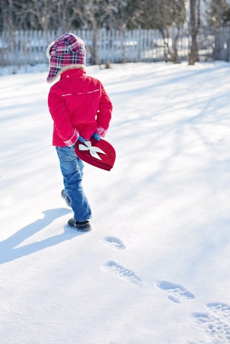 boy walking through the snow on valentineâs day