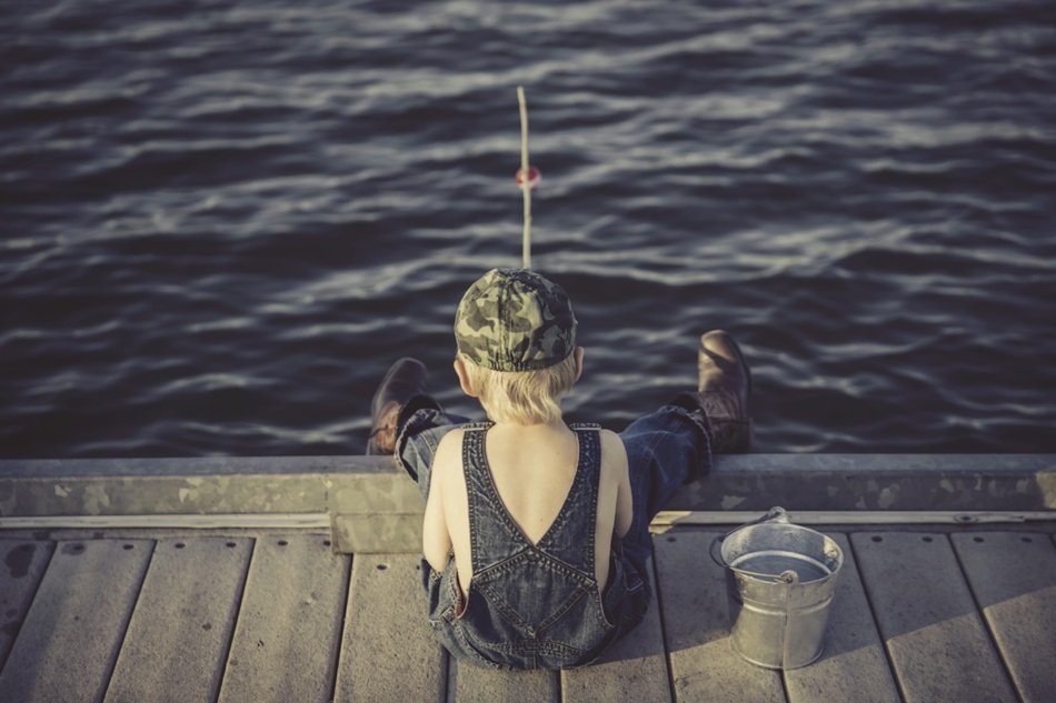 young boy fishing on pier