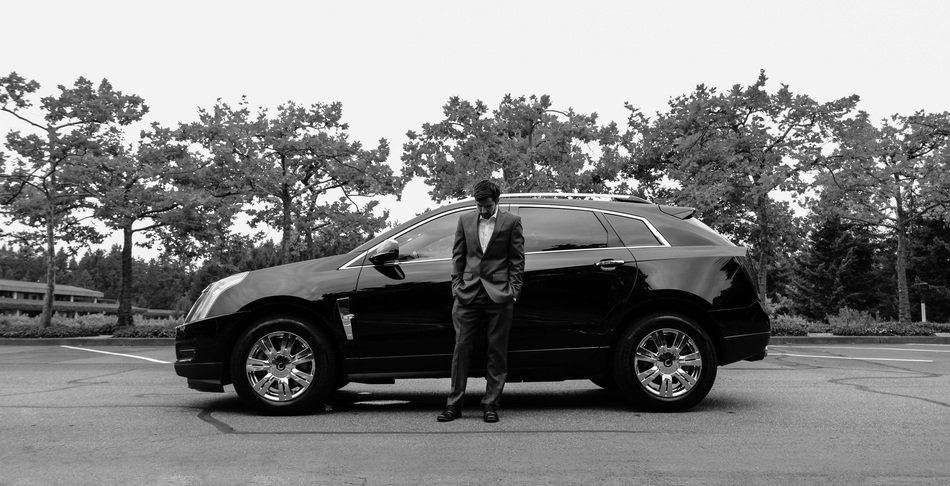 a man in a suit near a black car