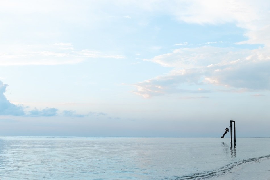 person swinging on the beach