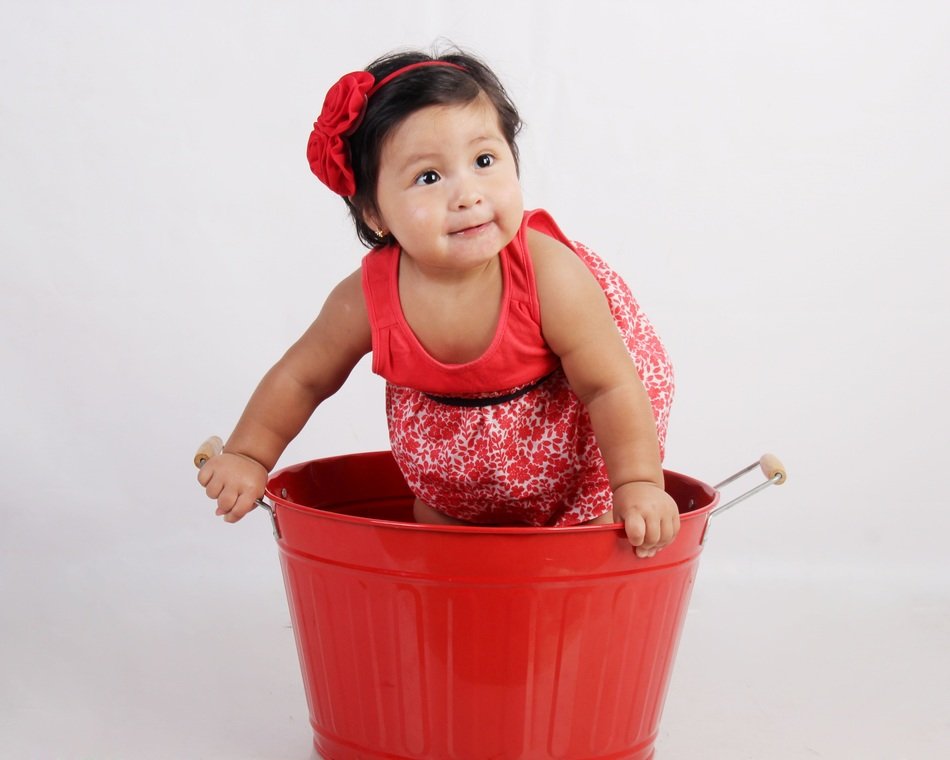 toddler's portrait in a red bucket