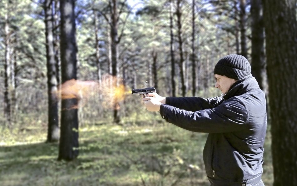 man with a firearm in the forest