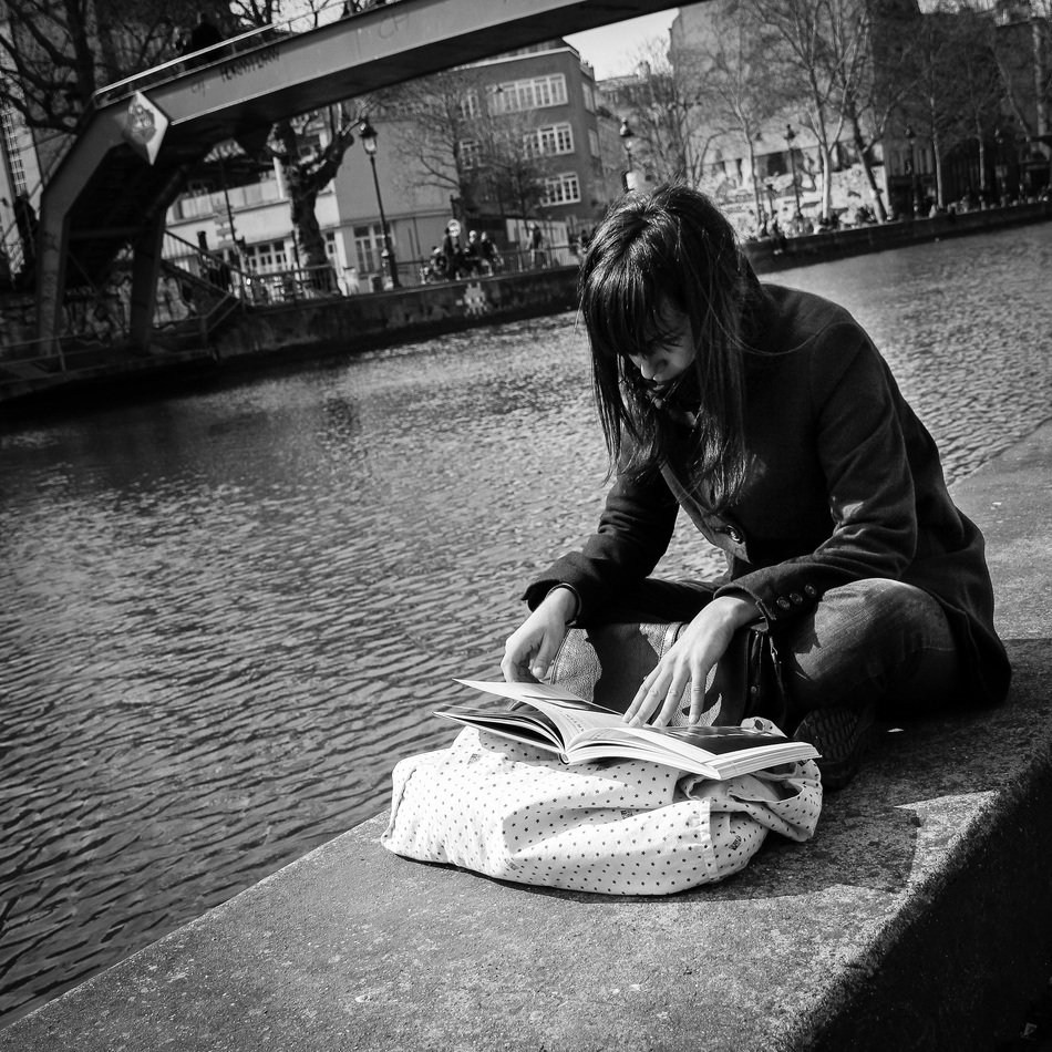 girl reads a book near canal saint martin