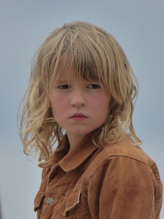 portrait of a girl with blond hair on a background of clear sky