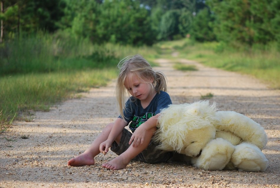 girl with teddy bear on the outdoors