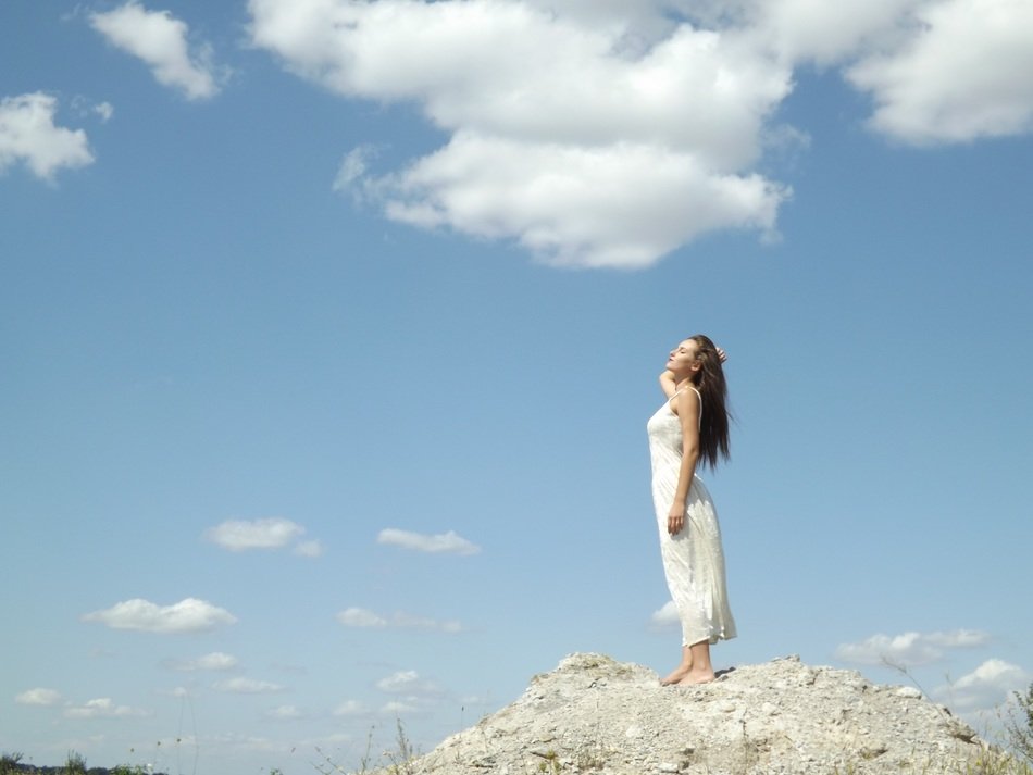 girl in white dress on background of the sky