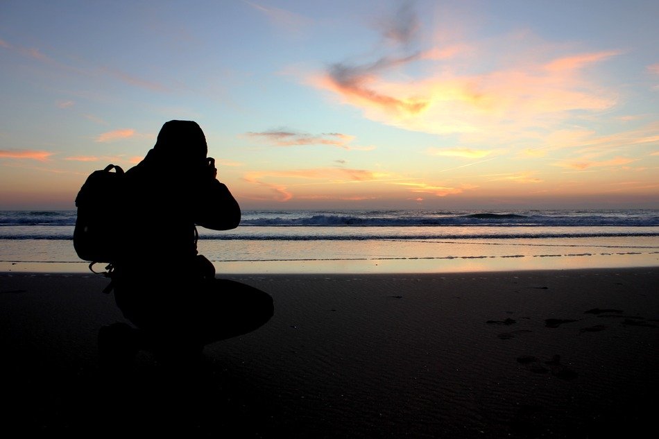 silhouette of the photographer on the beach at sunset in spain