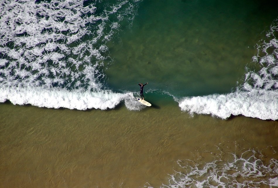 surfer in the wave of a bird's eye view