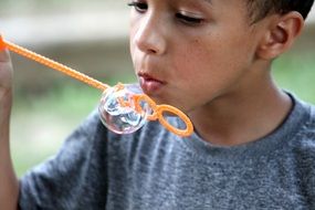 boy blowing soap bubble
