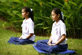 girls doing grass meditation